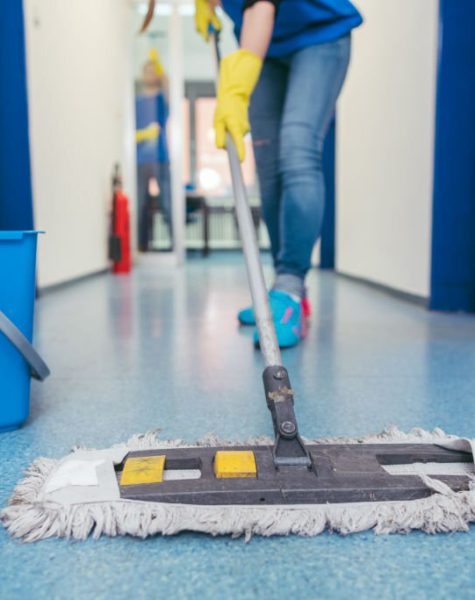 Close-up of cleaners moping the floor of a hall