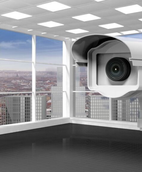 Empty office room with surveillance camera, skyscrapers and city view from the window